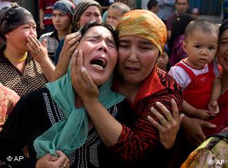 Uighur women grieve for their men who they claim were taken away by the Chinese authorities protest in Urumqi, China, Tuesday, July 7 , 2009