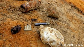 Archaeological dig site at Wijtschate, Belgium, excavating remnants of a World War I trench network; photo taken 06.07.2018. Various recently-excavated effects — a water bottle with a bullet hole in it, part of a British ammunition clip, the remainder of at least one shell, and some leather that was most likely part of a soldier's boot.