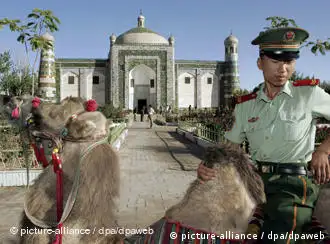 A Han Chinese paramilitary police officer rides a camel at the Apak Hojak Tomb, established in 1640 to commemorate the late influential king of the Islamic Uyhgur ethnic group in Kashgar, China's Xinjiang Uyghur Autonomous Region, Monday 29 August 2005. The Islamic Uyghurs comprise 75% of Kashgar's population and are the largest ethnic group in the autonomous region yet major industries such as oil, transportation and banking are controlled by Beijing. Xinjiang, which is five times geographically larger than France, was once a thriving part of the Silk Road until after the Tang Dynasty (618AD - 907AD) but is now mired in poverty compared with other regions of China. Foto: MICHAEL REYNOLDS +++(c) dpa - Report+++