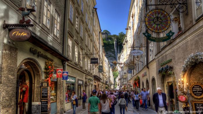 Tourists walk down the narrow Getreidegasse.