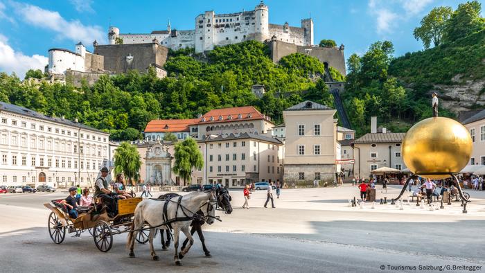 A view of Chapter Square, with a horse-drawn carriage and view of the fortress above. 