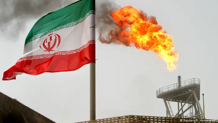 A gas flare on an oil production platform in the Soroush oil fields is seen alongside an Iranian flag in the Persian Gulf, Iran.