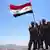 Suriye ordusuna mensup askerler Dera ilinde Suriye bayrağıyla poz veriyor, Temmuz 2018