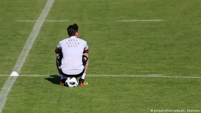 Mesut Özil sits on a ball during a training session (picture-alliance/dpa/C. Charisius)