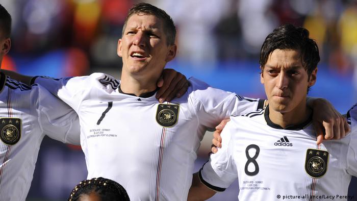 Sebastian Schweinsteiger y Mesut Özil cantando el himno nacional alemán.