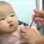 A Chinese medical worker vaccinates a baby at a disease control and prevention center in Handan city,