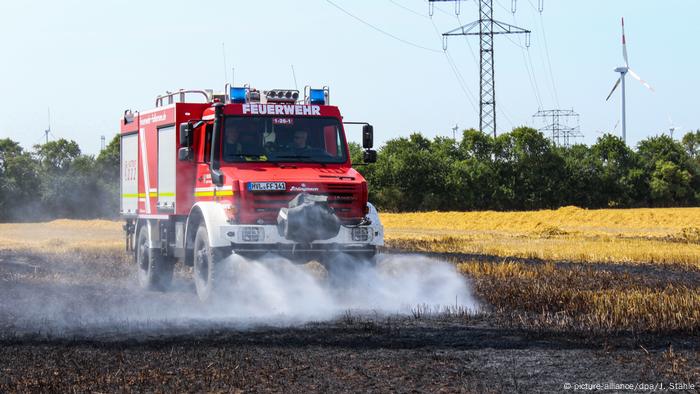 Carro de bomberos lanza agua en un campo