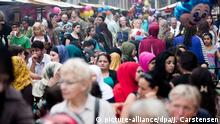 ARCHIV - Zahlreiche Besucher kommen am 30.07.2014 zum Ramadanfest auf der Karl-Marx-Straße in Berlin-Neukölln. Am 25.06.2017 feiern die Muslime das Fest des Fastenbrechens. Foto: Jörg Carstensen/dpa +++(c) dpa - Bildfunk+++ | Verwendung weltweit