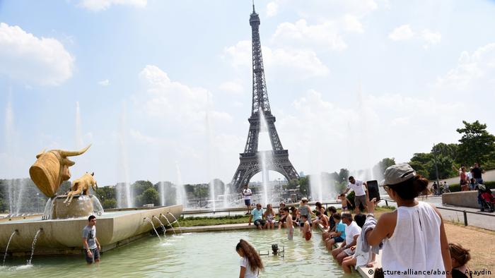 People dip their feet in Paris fountain (picture-alliance/abaca/A. Apaydin)