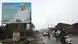 Cars and motorcycles pass an election billboard in Mali