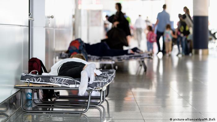 Passengers sleep on camp beds at Munich Airport