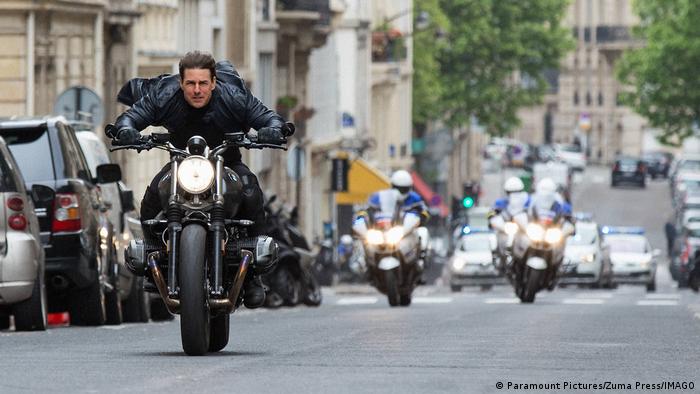 Tom Cruise flüchtet auf einem Motorrad vor mehreren Verfolgern. 
