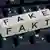 Слова FAKE и FAKT на кубиках и клавиатура компьютера