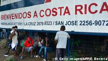 19.07.2016
Migrants by a banner that reads Welcome to Costa Rica in an encampment of Africans in Penas Blancas, Guanacaste, Costa Rica, in the border with Nicaragua on July 19, 2016. In a makeshift camp at barely one kilometer from the border, hundreds of tents shelter Haitians, Congolese, Senegalese and Ghanahian migrants waiting to continue their journey to the United States. / AFP / Ezequiel Becerra / TO GO WITH AFP STORY BY MARCO SIBAJA (Photo credit should read EZEQUIEL BECERRA/AFP/Getty Images)