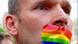 Man with the rainbow flag covering up his mouth Man with the rainbow flag covering up his mouth