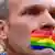 Man with his mouth taped closed with rainbow tape