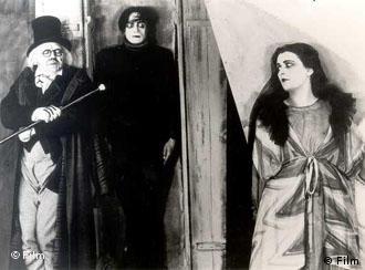 Szene aus Das Cabinet des Dr. Caligari: drei Personen vor Filmdekor (Foto: Film)