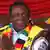 A smiling Emmerson Mnangagwa, wearing a ZANU-PF scarf, Präsident