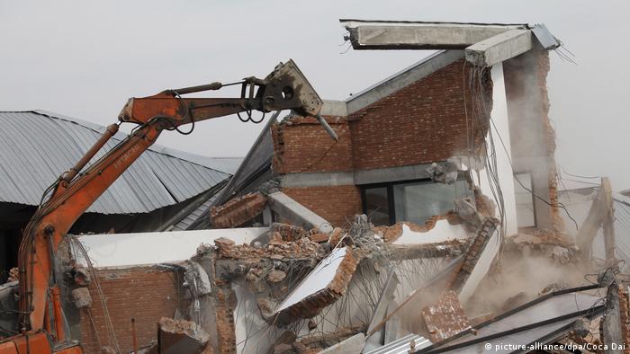 A wrecking machine tearing down the studio of renowned Chinese artist Ai Weiwei on the outskirts of Shanghai, China