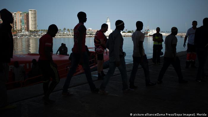 Migrants walking to a Red Cross tent in Spain