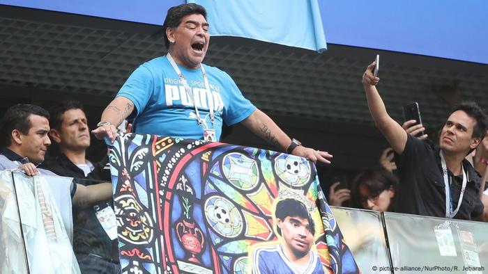 Diego Maradona unfurls a banner of himself as a football saint in the 2018 FIFA World Cup in Russia