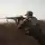 A Kurdish Peshmerga fighter firing a rifle 