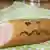A sausage with a frowny face drawn on it