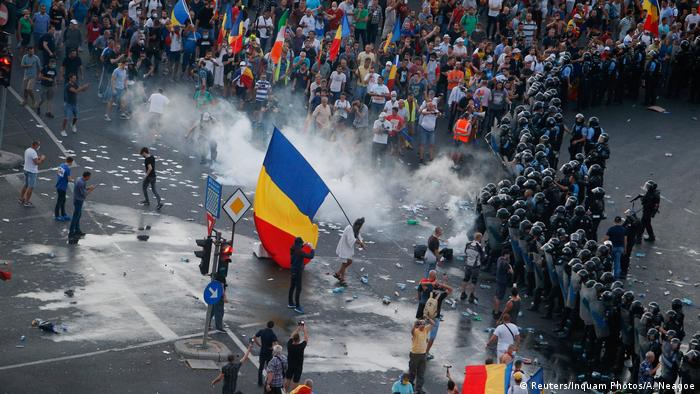 Protesters stand in front of police during a demonstration in Bucharest, Romania,