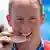 German swimmer Thomas Lurz bites his gold medal for the cameras after his win this Tuesday