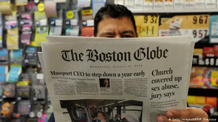 in a shop in Bosten, a man reads an 2018 issue of The Boston Globe newspaper with headline Chruch covered up sex abuse, jury says