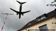Dicht über ein Hausdach fliegt am 03.06.2016 in Düsseldorf (Nordrhein-Westfalen) eine Passagiermaschine beim Landeanflug auf den Flughafen Düsseldorf. Foto: Horst Ossinger/dpa | Verwendung weltweit