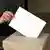 woman putting ballot in box