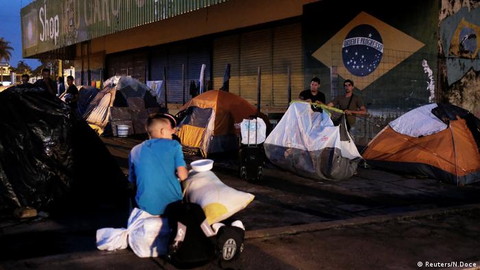 Brasilien, Venezolanische Männer errichten ihr Zelt, während sie warten, um ihre Pässe am nächsten Tag an der Pacaraima Grenzkontrolle zu zeigen (Reuters/N.Doce)