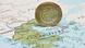 Νόμισμα του ενός ευρώ πάνω σε χάρτη της Ελλάδας
