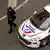 French police officer walks alongside a police car on April 10, 2018