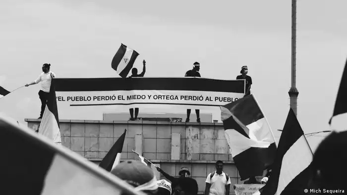 Exposición fotgráfica Miradas en Resistencia. Ciudadnos nicaragüenses desde la rotonda de metrocentro, alzando las banderas azul y blanco. (Mich Sequeira).