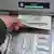 Eine Hand entnimmt dem Geldschlitz eines Bankautomaten Banknoten (Foto: dpa)