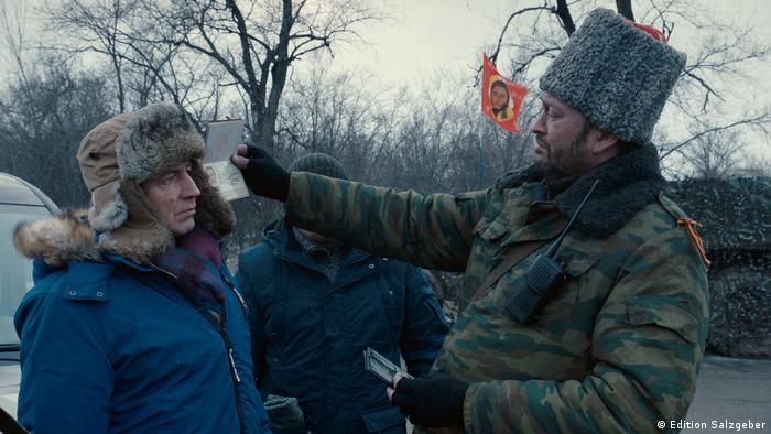 Filmstill Donbass von Sergey Loznitsa: ein Soldat überprüft den Ausweis eines Mannes