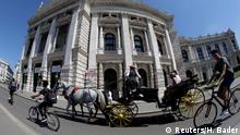 August 13, 2018, A traditional Fiaker horse carriage passes Burgtheater theatre in Vienna, Austria, . REUTERS/