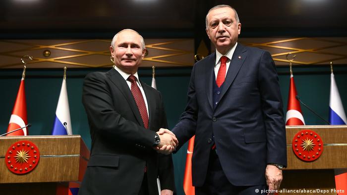 Turkish President Recep Tayyip Erdogan shakes hands with Russian President Vladimir Putin