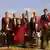 Ein 8-köpfiges Musikerensemble in rotem Frack und dunklen Hosen, mit Insturmenten posierend vor grüner Landschaft(Copyright: Kurverwaltung Juist)