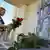 A woman places flowers in front pictures of the leader of the separatist self-proclaimed Donetsk People's Republic, Alexander Zakharchenko