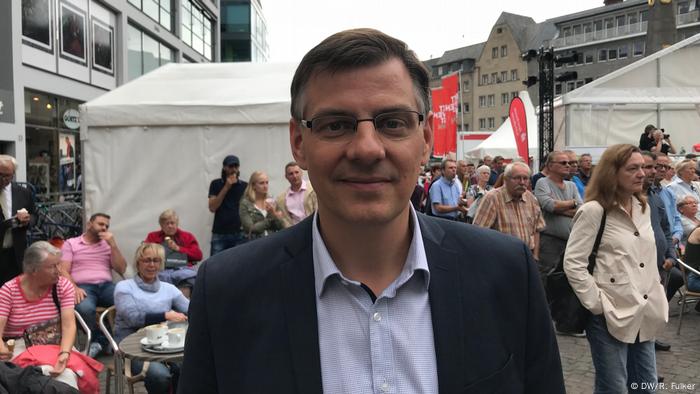 Beethovenfest 2018 (DW/R. Fulker) Man in a suit and glasses smiles at the camera in Bonn's main square.