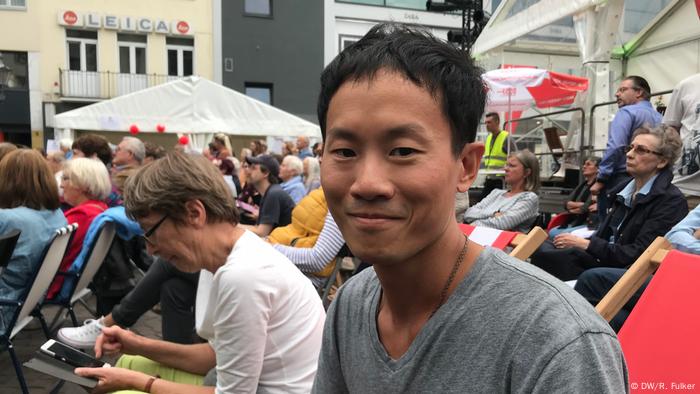 Beethovenfest 2018 (DW/R. Fulker) Man in a grey T-shirt smiles while sitting in Bonn main square.