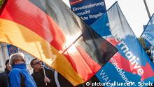 Anhänger der Partei Alternative für Deutschland (AfD) halten am 31.10.2015 in Hamburg während einer Kundgebung eine Fahne mit der Aufschrift Mut zur Wahrheit, die Deutschlandfahne und ein Plakat mit der Aufschrift «Einwanderung braucht strikte Regeln» hoch.
Foto: Markus Scholz | Verwendung weltweit