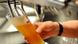 Someone pours a beer from a tap into a large glass Someone pours a beer from a tap into a large glass