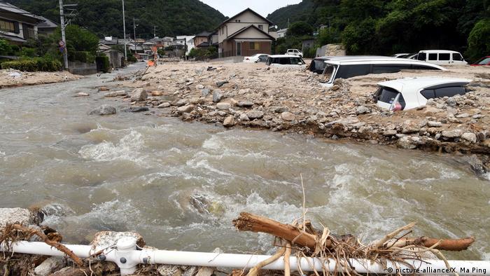 Photo taken on July 11, 2018, shows floodwater flowing by a village in Kure, Hiroshima