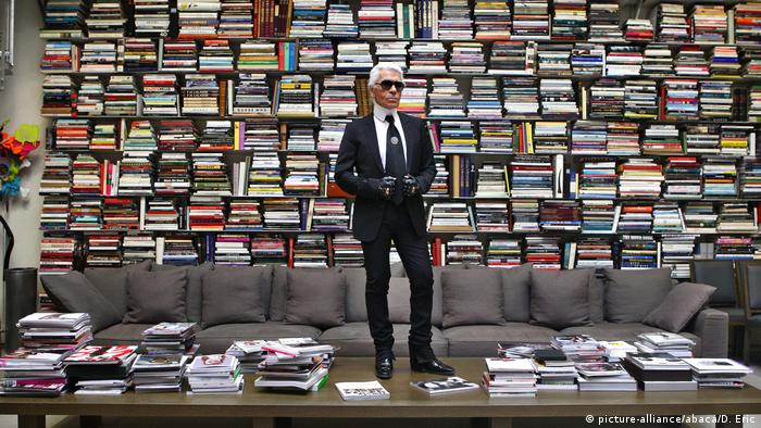 Karl Lagerfeld steht vor einem riesigen, mit Büchern befüllten Regal. (picture-alliance/abaca/D. Eric)