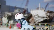 FILE - In this Feb. 10, 2016, file photo, a Tokyo Electric Power Co. (TEPCO) employee, wearing a protective suit and a mask, walks in front of the No. 1 reactor building at the tsunami-crippled Fukushima Dai-ichi nuclear power plant in Okuma, Fukushima Prefecture, northeastern Japan. Five years after a powerful earthquake and tsunami sent the nuclear power plant in the country into multiple meltdowns, cleaning up the mess both onsite and in surrounding towns remains a work in progress. (Toru Hanai/Pool Photo via AP, File) |