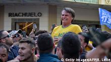 Brazilian right-wing presidential candidate Jair Bolsonaro gestures after being stabbed in the stomach during a campaign rally in Juiz de Fora, Minas Gerais State, in southern Brazil, on September 6, 2018. - Frontrunner Bolsonaro was attacked with a knife while campaigning -- but escaped with just minor injuries, his son said. (Photo by Raysa LEITE / AFP) / RESTRICTED TO EDITORIAL USE - MANDATORY CREDIT AFP PHOTO /RAYSA LEITE - NO MARKETING NO ADVERTISING CAMPAIGNS - DISTRIBUTED AS A SERVICE TO CLIENTS (Photo credit should read RAYSA LEITE/AFP/Getty Images)